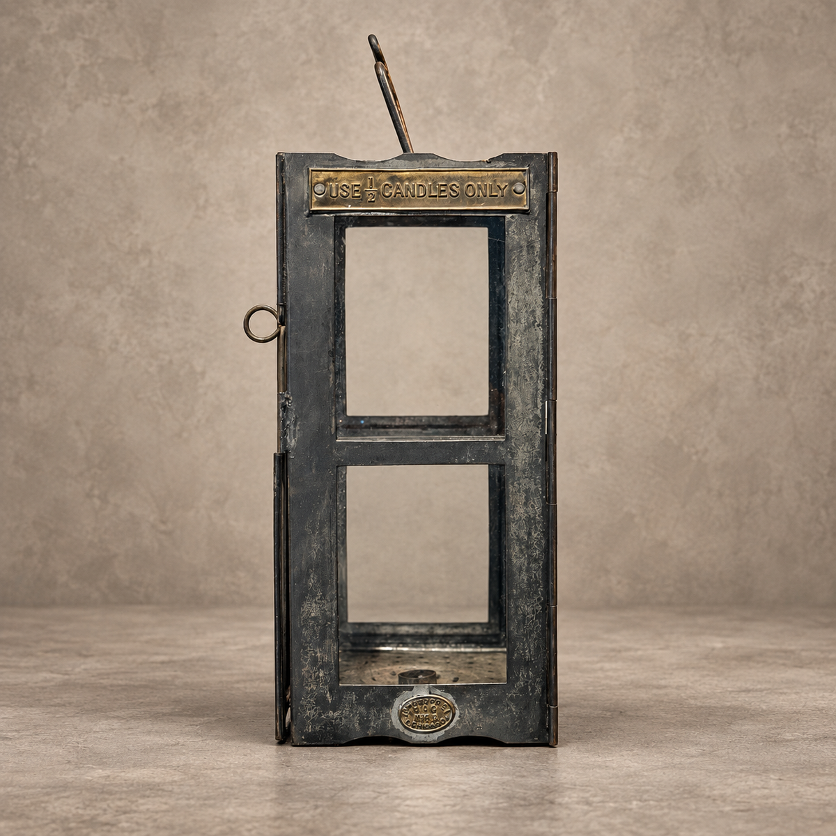 A rustic, vintage-style metal candle holder designed in the shape of a classic telephone booth, featuring distressed dark gray and bronze metal finishes with a brass-colored sign at the top reading 'CANDLE HOLDERS ONLY'.