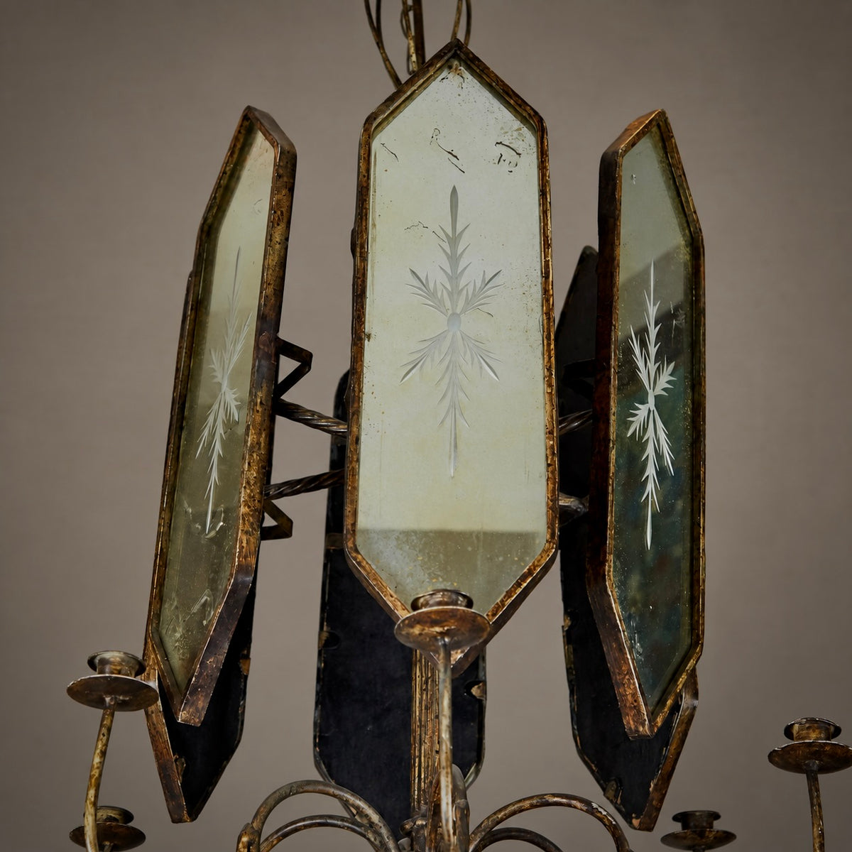 An antique three-light chandelier featuring distressed bronze metal frames and etched glass panels with snowflake-like patterns, shown against a neutral background.