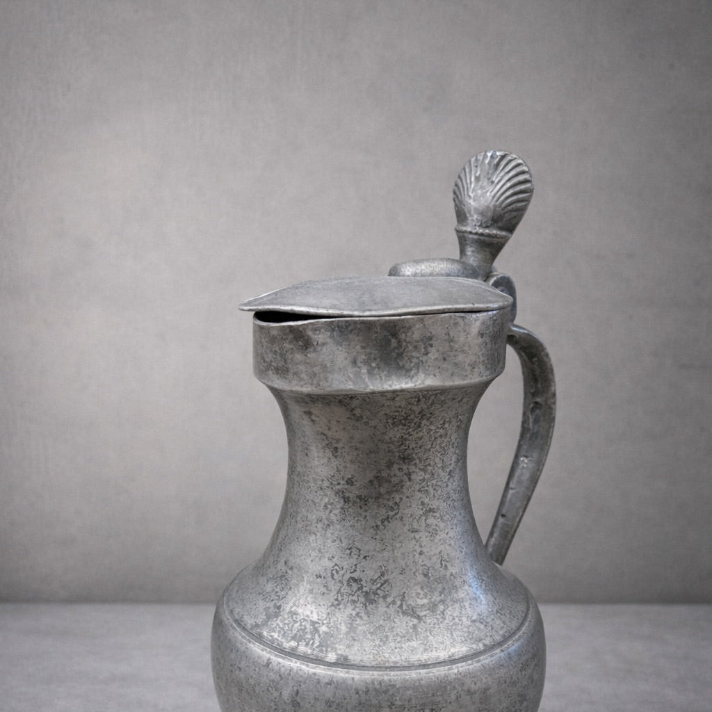 Vintage-style metal pitcher on a gray background