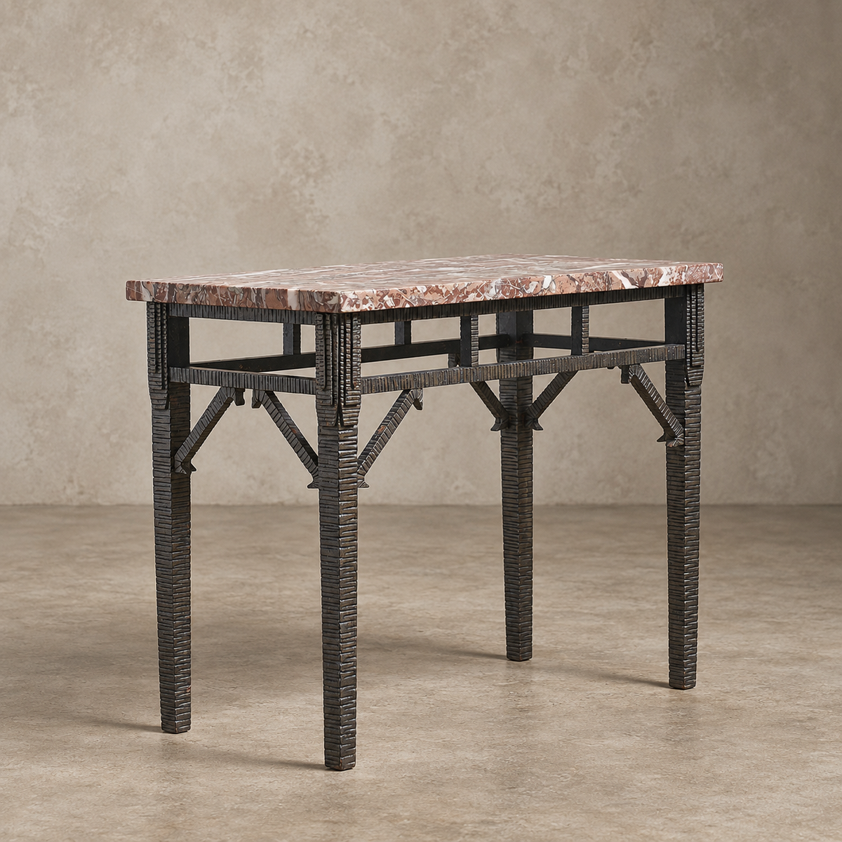 A rectangular console table with a warm pinkish-brown marble top and a dark woven rattan frame, set against a textured beige studio backdrop.