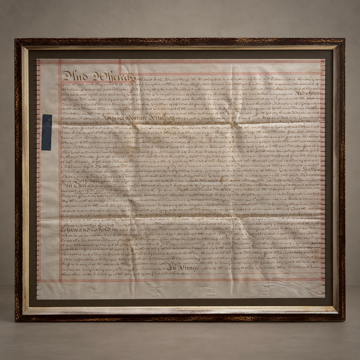 A framed property deed, featuring the original parchment document inside a large, ornate dark brown wooden frame.