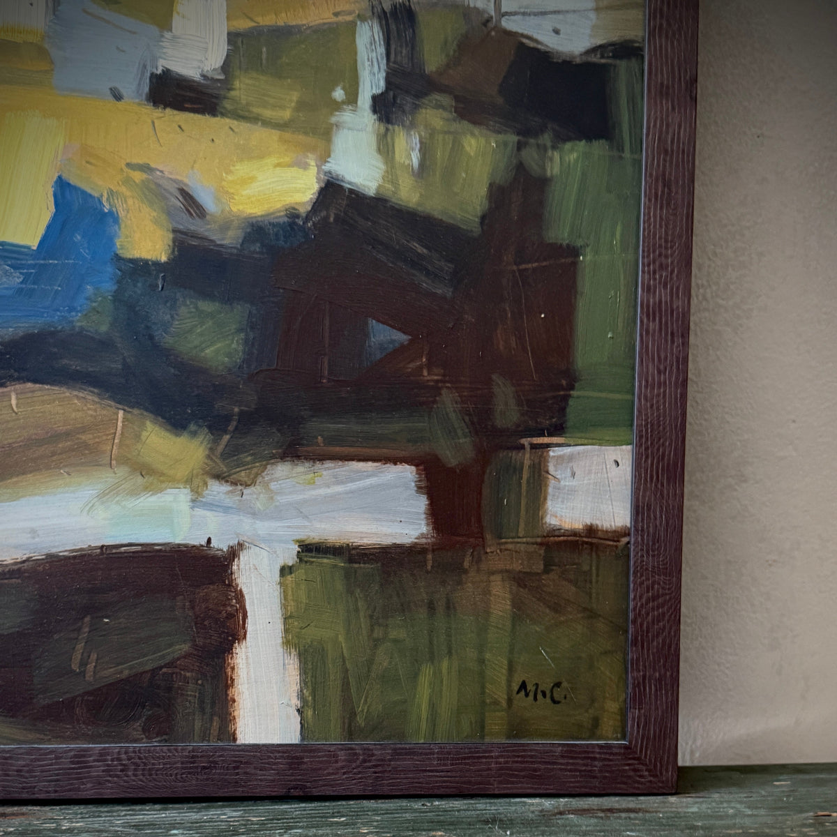 Abstract painting with a signature on a wooden surface