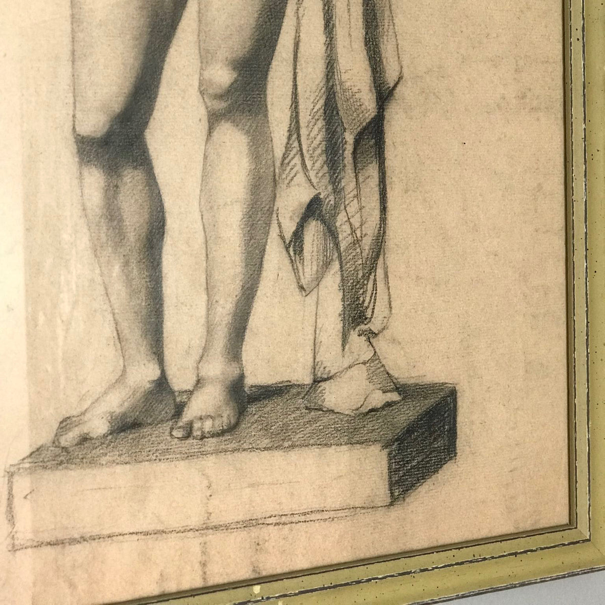 Close up of 19th-century academic charcoal drawing of a standing male nude with drapery, presented in a giltwood frame.