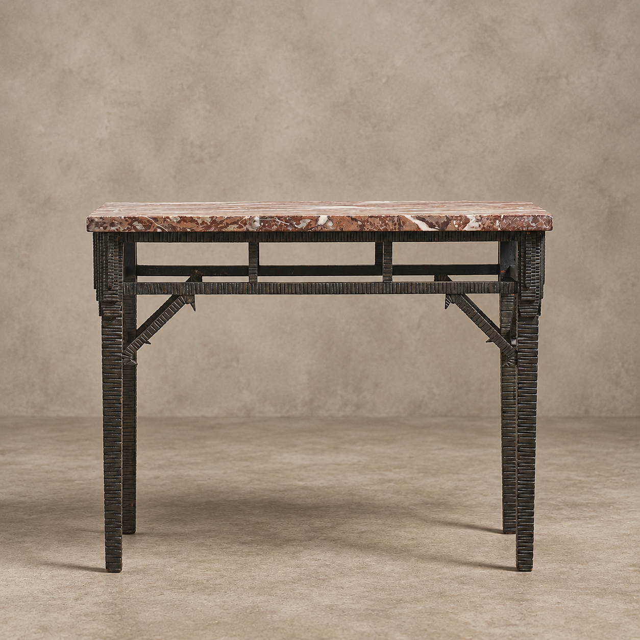 A console table featuring a rectangular reddish-brown marble top and a dark woven rattan frame with geometric metal support brackets, set against a textured beige studio backdrop.