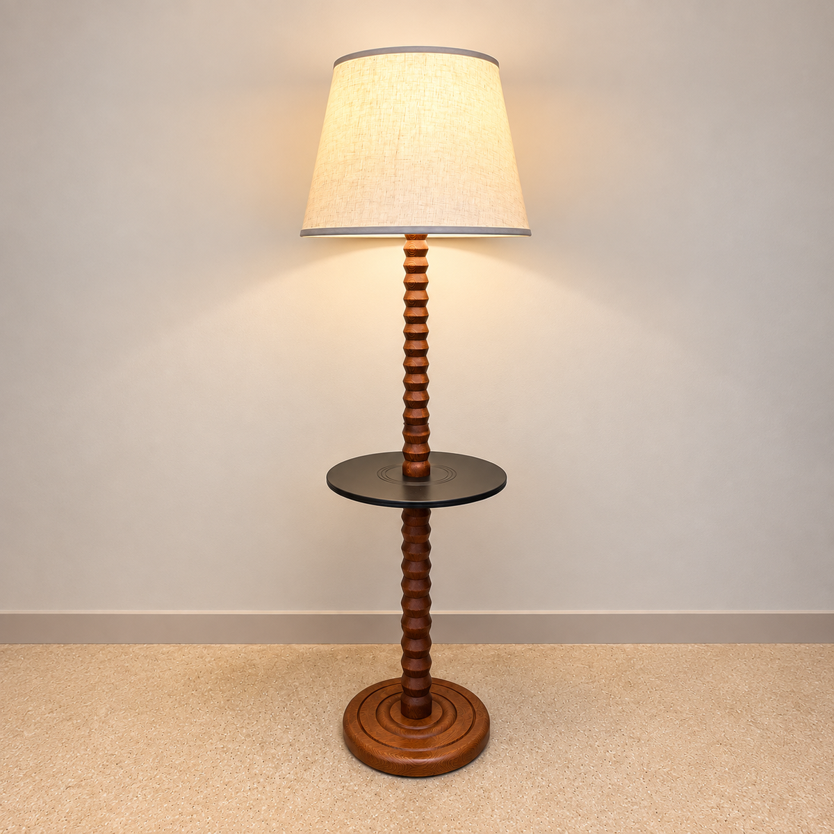 A floor lamp with a tapered beige fabric shade, a dark round side table in the middle, and a twisted wooden pedestal base on a beige carpeted floor against a plain wall.