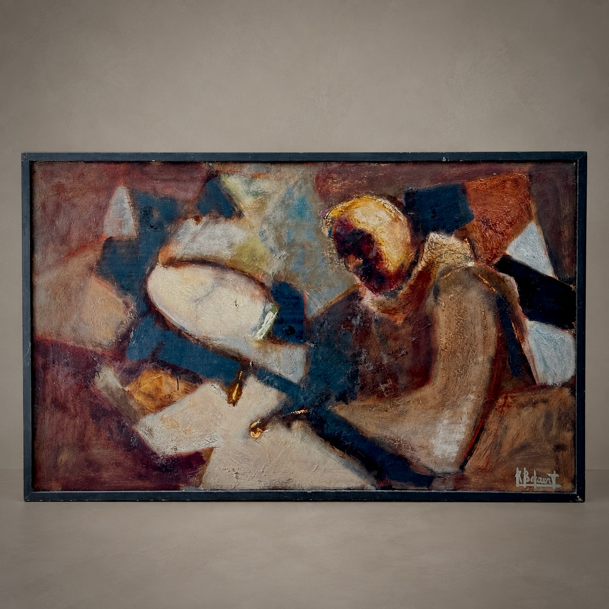 An abstract expressionist painting depicting a seated figure with a drum, rendered in earthy tones of brown, beige, blue, and black, housed in a dark frame against a neutral gray wall.