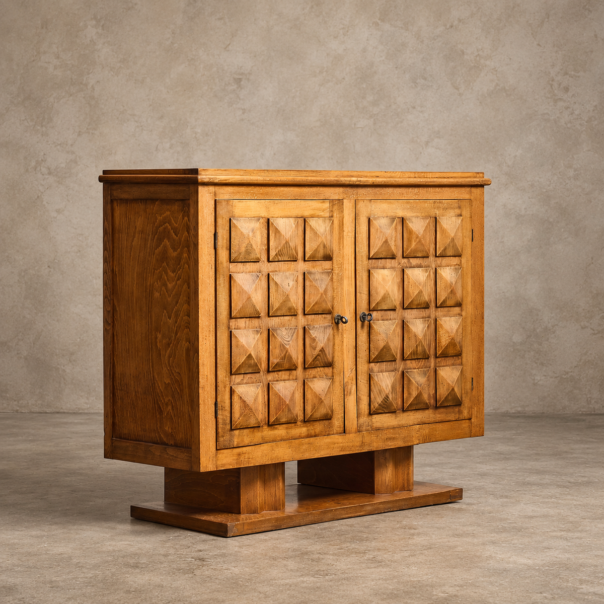 A mid-century modern wooden sideboard cabinet with geometric pyramid-carved doors, set against a textured concrete wall and floor.