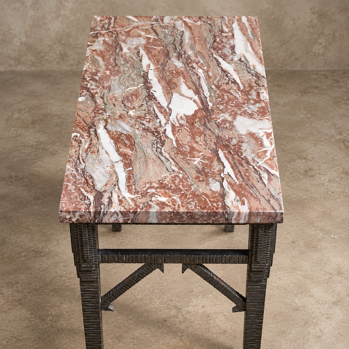A rectangular console table featuring a polished pinkish-brown marble top with white and gray veining, supported by a dark metal frame with textured legs.