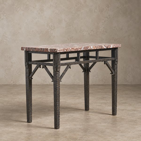 A rectangular console table with a warm pinkish-brown marble top and a dark woven rattan frame, set against a textured beige studio backdrop.