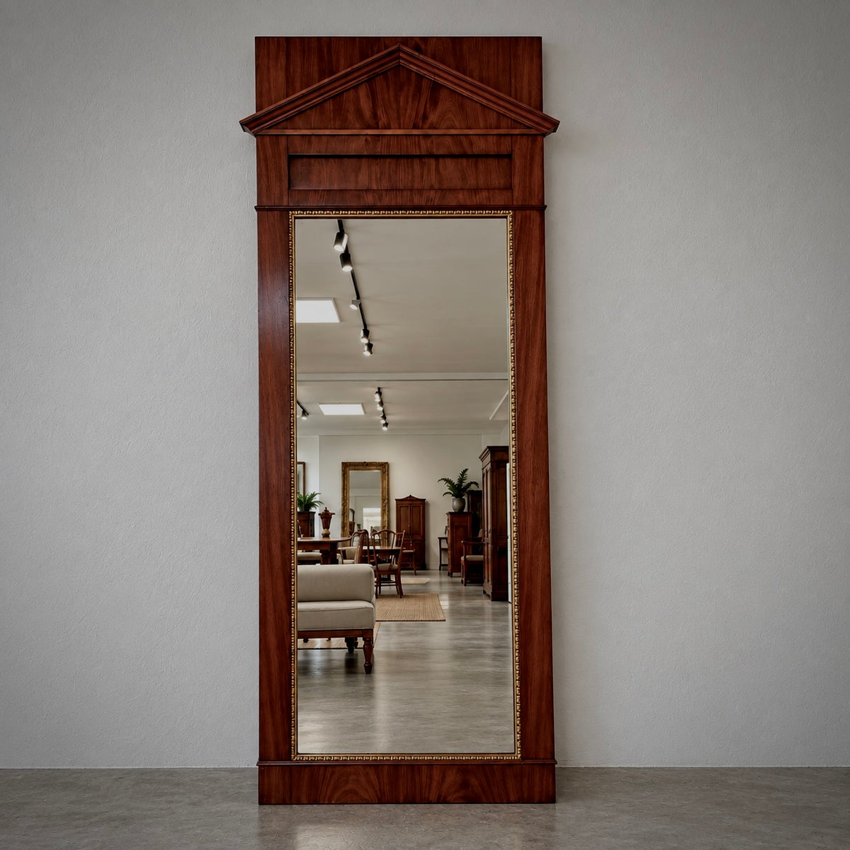 Tall mahogany architectural pier mirror with classical pediment, rich figured wood grain, and delicate gilt beaded trim surrounding the mirror plate