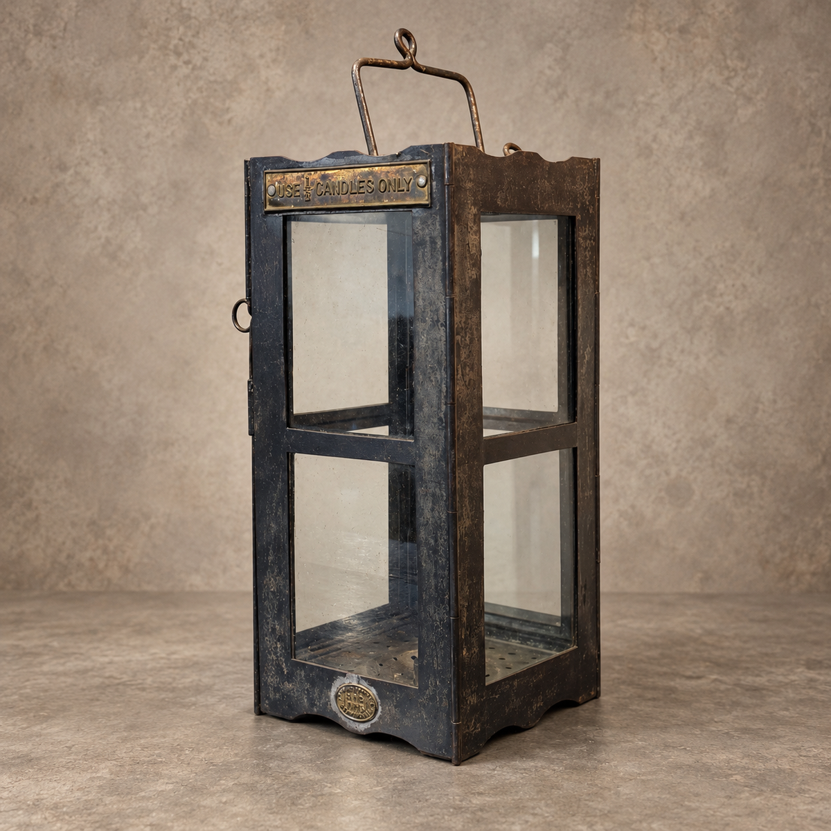 A vintage-style lantern with a distressed dark blue and brown wood finish, clear glass panels, and brass metal accents, set against a textured beige background.