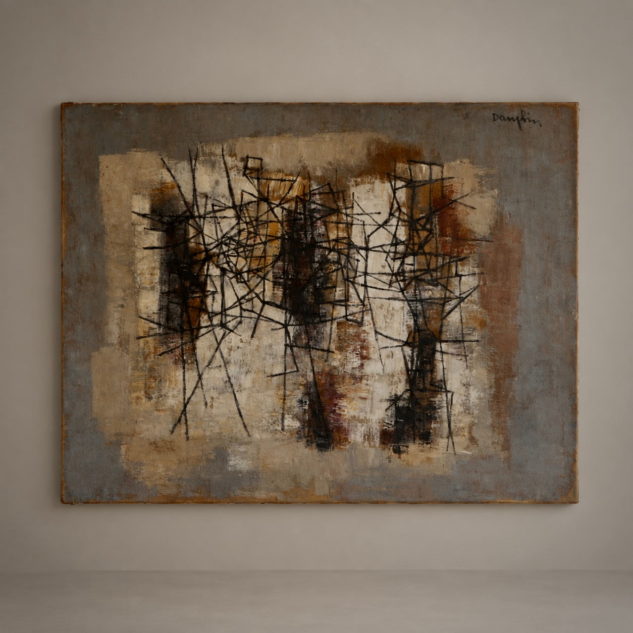 An abstract expressionist painting hanging on a neutral gray gallery wall. The artwork features a textured, layered background of beige, brown, and gray tones overlaid with chaotic, energetic black and dark brown scribbled lines.