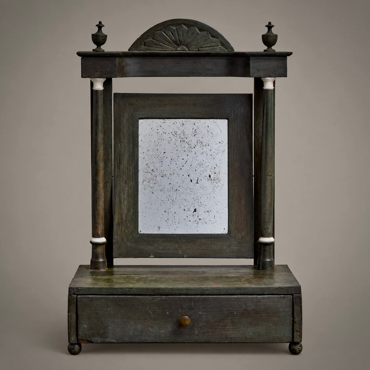 An antique metal fan-shaped window divider with a decorative wire fan pattern, mounted on a plain light gray background