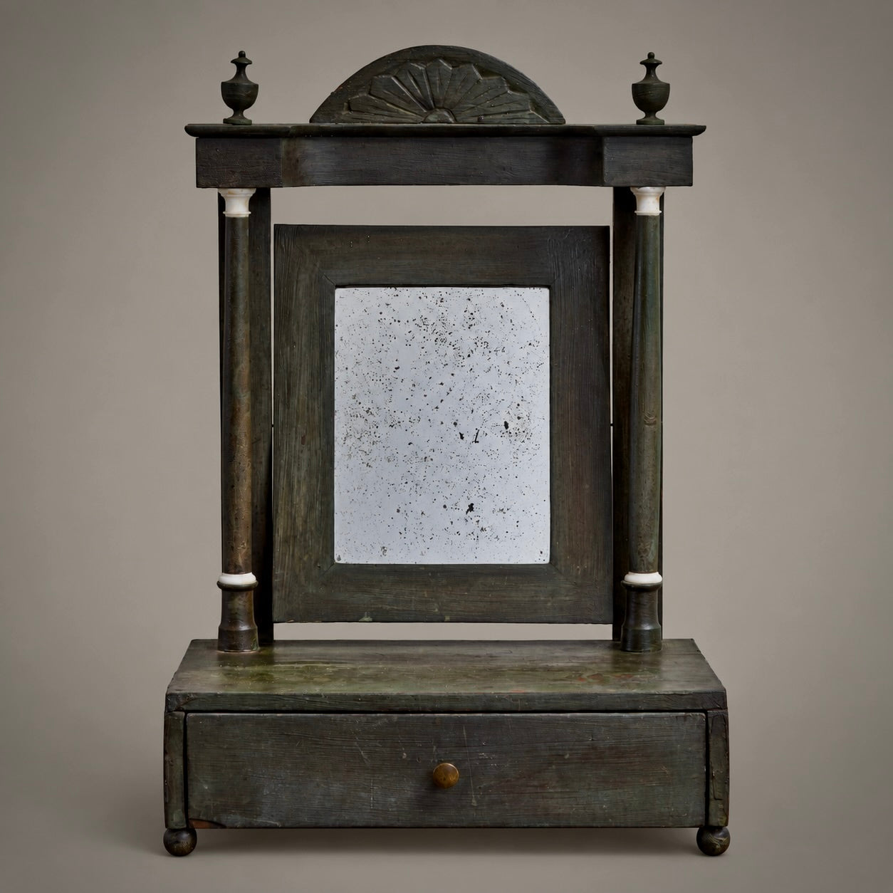 An antique metal fan-shaped window divider with a decorative wire fan pattern, mounted on a plain light gray background