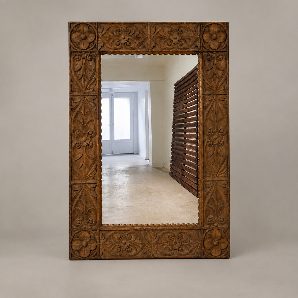 A large rectangular wall mirror with an ornate, carved dark brown wooden frame, shown against a neutral light gray background.