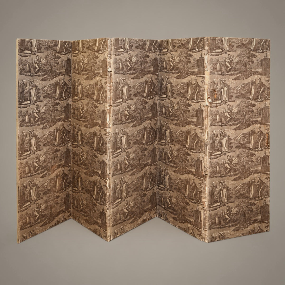 A five panel folding screen with an all-over classical relief sculpture pattern in earthy brown and beige tones, photographed against a neutral gray background.