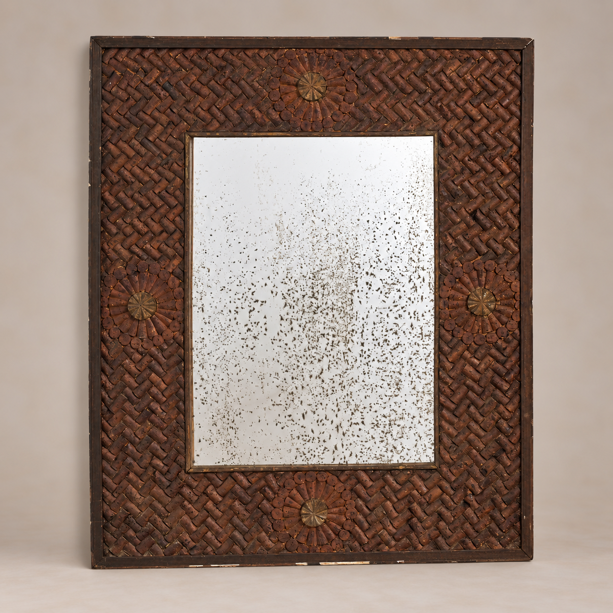 A rectangular wall mirror with a dark brown woven rattan frame and decorative starburst medallions in the corners, set against a neutral beige background.