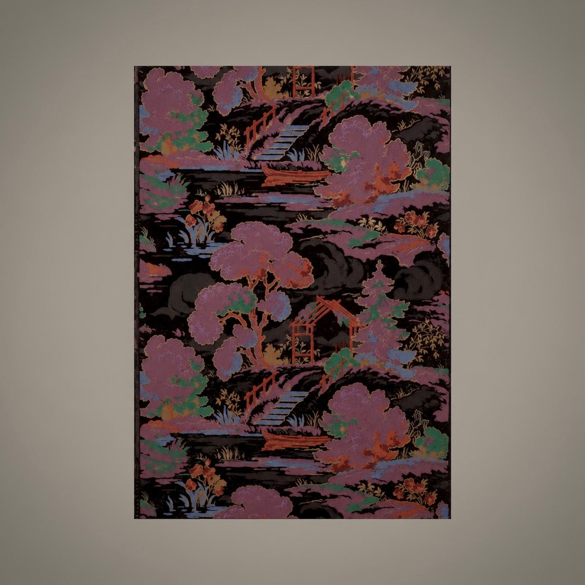 A vertical rectangular wall art print featuring an ornate scenic pattern with pink trees, bridges, water, and small pavements over a dark background, centered on a plain taupe wall.