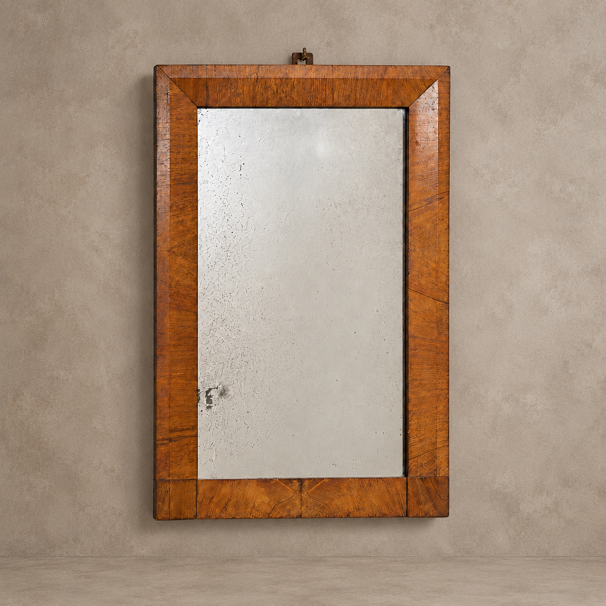 A rectangular wall mirror with a thick, warm brown wood frame, mounted on a textured beige plaster wall.