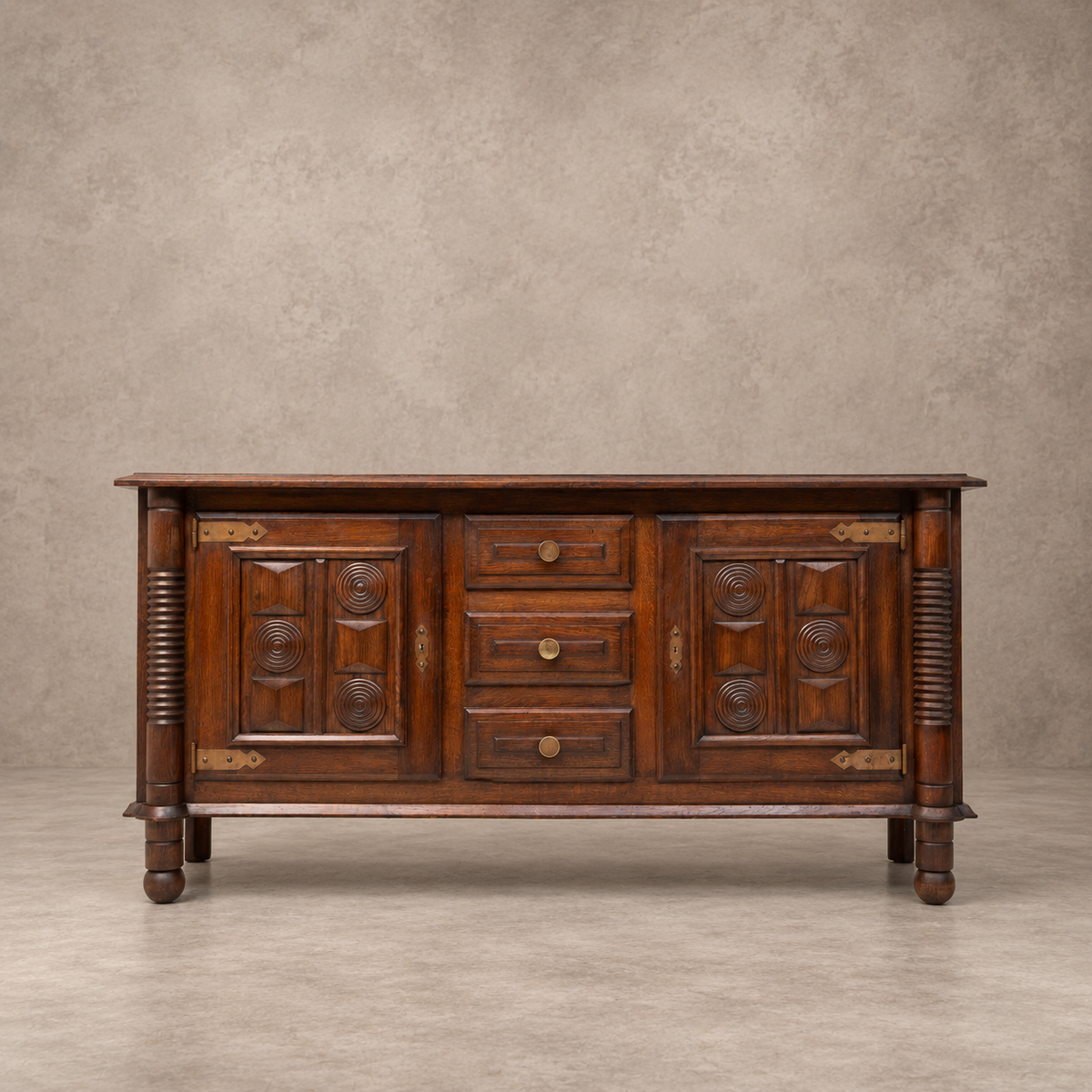 A traditional dark brown wooden sideboard cabinet with carved details, three drawers, and brass hardware, set against a textured beige studio backdrop.