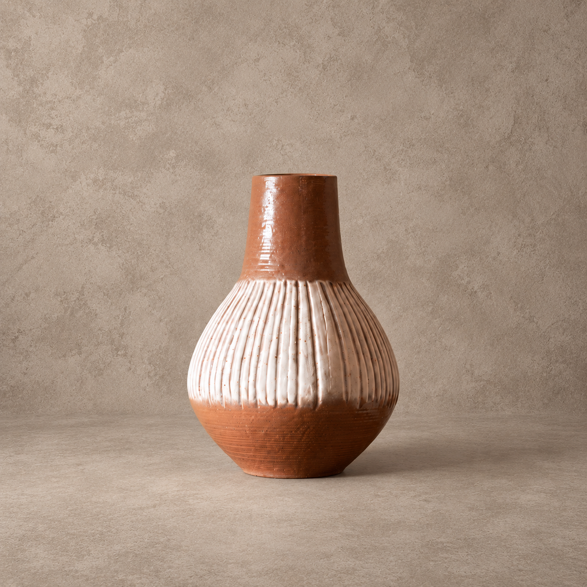 A handmade ceramic vase with a bulbous ribbed body, a flared brown neck, and a textured matte finish, set against a neutral concrete-textured background.
