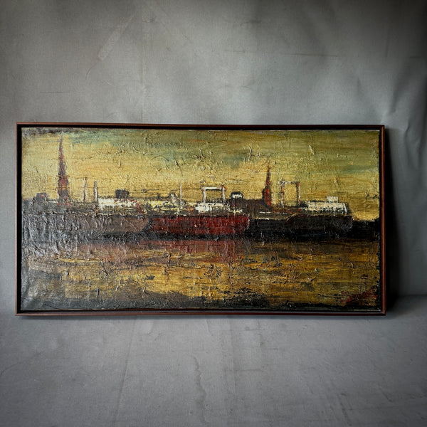 A late 19th-century Belgian oil painting of Antwerp port featuring three ships docked at sunset with an industrial cityscape in the background, housed in a simple wooden frame.