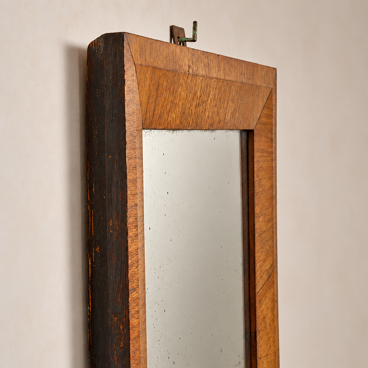 A rustic wall mirror with a thick wooden frame, featuring a dark brown distressed side panel and a warm medium-brown beveled inner border, mounted on a beige wall.
