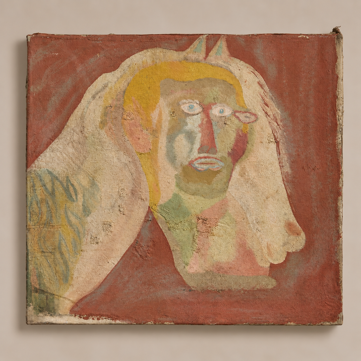 A square abstract painting depicting a stylized face with a yellow halo-like shape on a reddish-brown background, shown against a plain light beige wall.